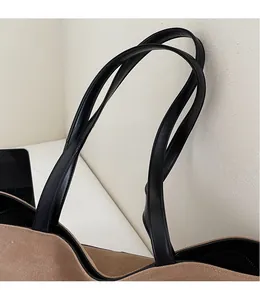 Detail of premium khaki canvas texture with black leather strap stitching on tote bag