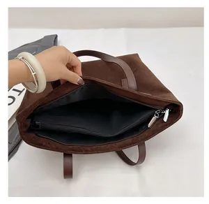 Vista interna della grande borsa tote in pelle scamosciata marrone con tasca zip