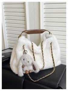 Dettaglio borsa tote in peluche bianca con tracolla in catena e ciondolo a coniglio