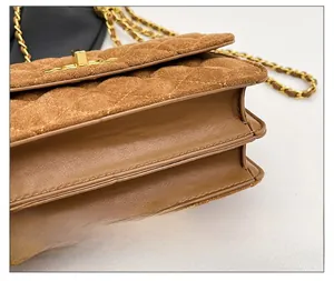 Detail view of brown quilted suede and leather bag with gold chain and metal lock
