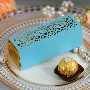 Macro shot of light blue laser-cut heart favor box with golden details for weddings