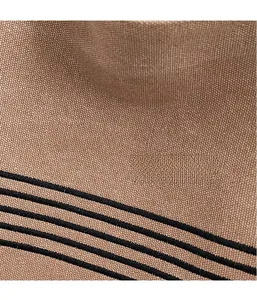 Detailed macro view of durable brown canvas fabric with black embroidered stripes
