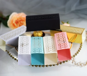Macro detail of laser-cut hollow pattern on colorful wedding candy gift boxes