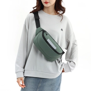Detail of waterproof dark green crossbody bag with adjustable strap and reflective safety strip