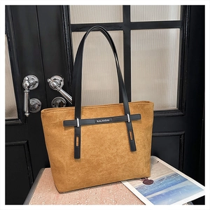 Dettaglio della borsa tote in pelle scamosciata marrone con manici in pelle nera