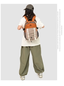 Detailed back view of a person wearing a tricolor waterproof outdoor backpack in grey and orange