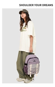 Detail view of purple and grey nylon waterproof backpack with functional mesh pocket and cords