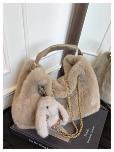 Dettaglio borsa tote in ecopelliccia color cammello con catena d'oro e ciondolo a coniglio