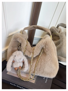 Dettaglio borsa a mano beige in peluche con manici in pelle, catena e ciondolo a coniglio