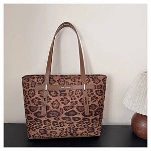 Dettaglio della borsa tote leopardata con manici in pelle marrone e logo del brand