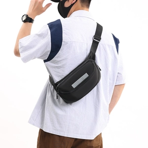 Close-up of black crossbody chest bag with silver reflective safety strip and durable fabric