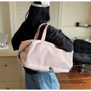 Detailed view of pink duffel bag showing independent bottom shoe compartment and handles