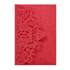 Close-up of red glitter laser-cut floral pattern on festive wedding invitation card