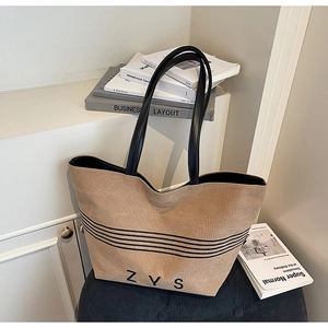 Detail shot of the striped canvas tote bag with black leather straps and ZYS print