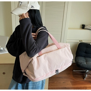Detail of light pink travel bag showing the bottom shoe compartment and side zipper