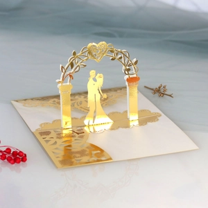 Detailed laser-cut 3D wedding invitation featuring a gold foil silhouette under a floral arch