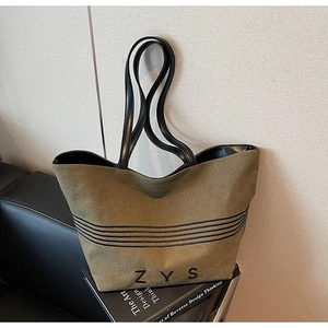 Detail showing the thick olive green canvas material and striped base of this tote bag