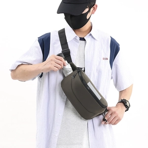 Detail showing high-capacity waterproof chest bag holding a compact umbrella