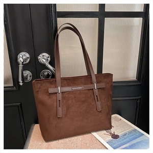 Dettaglio della borsa tote in pelle scamosciata marrone con striscia metallica