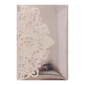 Macro shot of silver laser-cut floral lace pattern on an elegant wedding invitation