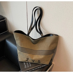 Detail of olive green canvas tote bag showing the black ZYS logo and striped patterns