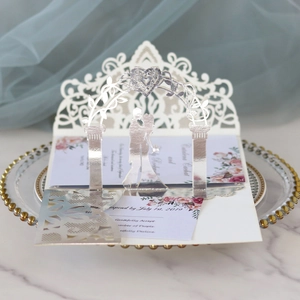 Detail showing 3D laser-cut wedding invitation with intricate lace floral patterns