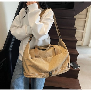 Detail view of khaki travel bag with durable dual zippers and adjustable shoulder strap