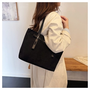 Borsa tote nera opaca minimalista con cinturino decorativo in metallo su modella