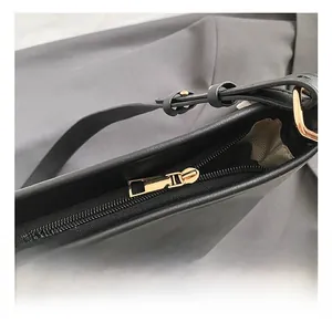 Details des goldenen Metallreißverschlusses und der schwarzen Lederbeuteltasche