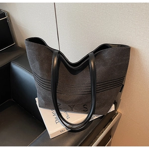 Detailed macro view of dark grey striped canvas tote bag with ZYS logo and leather strap
