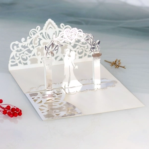 Detail of 3D laser-cut wedding invitation featuring a romantic couple silhouette under an arch