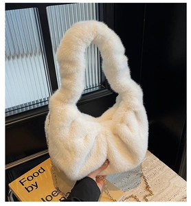 Detailed macro view of plush white faux fur handbag with elegant gold metal chain strap