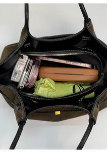 Vertical view of the spacious tote bag interior with zip compartments and daily items