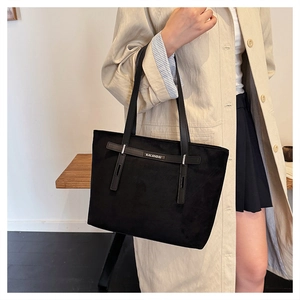 Dettaglio della borsa tote nera opaca con cinturini in pelle e logo KALANDAI inciso