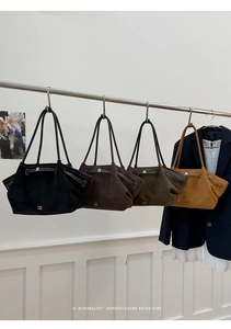 Detail of four colorful suede tote bags with golden lettering and slim shoulder straps