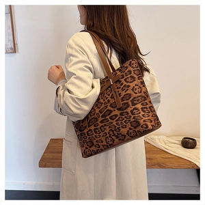 Vista dettagliata della borsa tote leopardata con cinturini in pelle marrone su modella