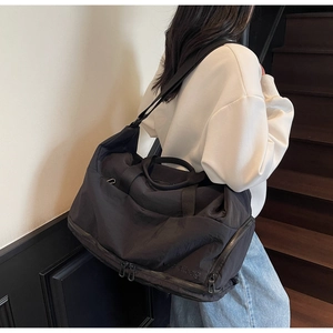 Close-up of black travel bag showing durable nylon texture and bottom storage compartment
