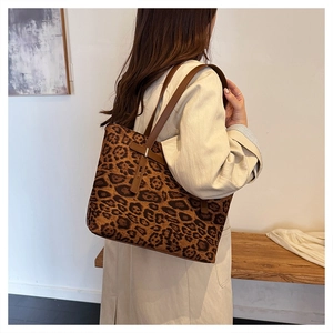 Dettaglio della borsa tote leopardata grande con manici in pelle indossata da una modella