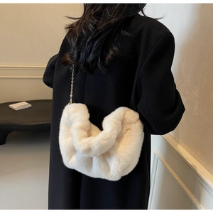 Detail of faux fur crossbody bag featuring soft plush texture and golden chain strap