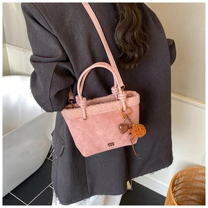 Dettaglio borsa a secchiello rosa in peluche con texture scamosciata e pendente a cuore