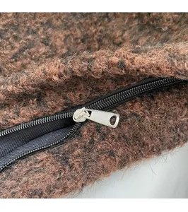 Detail van de zilveren metalen rits op de bruine pluche bucket bag voor dames