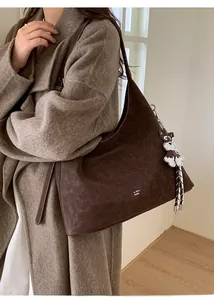 Close-up of deep brown tote bag featuring white contrast stitching and puppy bag charm