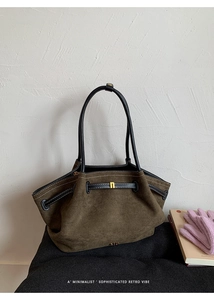 Detail of dark brown faux suede tote bag with black leather handle and gold hardware