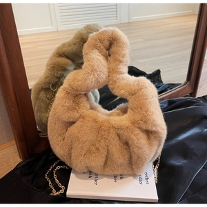 Detail of camel plush faux fur cloud bag with knotted handle and golden metal chain