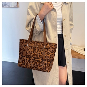 Dettaglio della borsa tote leopardata con cinturino in pelle e logo metallico KALANDAI