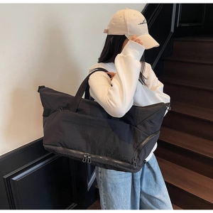 Detail of black travel bag with bottom expansion zipper and durable nylon texture