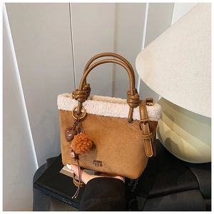 Dettaglio borsa a secchiello in camoscio marrone con bordo in ecopelliccia bianca e logo