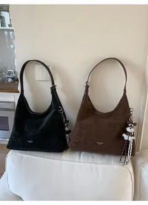 Detail of vintage suede hobo bags in black and brown with Muon Shark logo and puppy charm