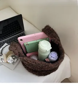 Ruime binnenkant van bruine pluche shopper met tablet, waterfles en paraplu erin
