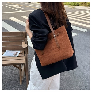 Dettaglio della borsa tote in pelle scamosciata marrone con manici in pelle e fibbia